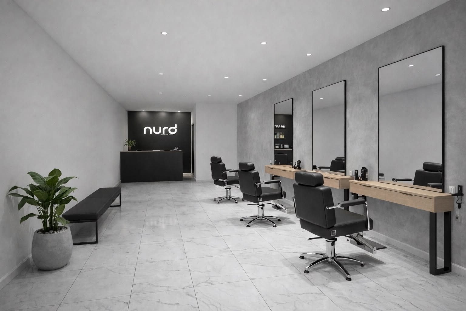 Le salon : murs béton, fauteuils noirs, grands miroirs, une plante